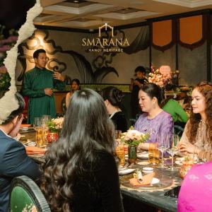 河内Smarana Hanoi Heritage - Hotel and Retreats的一群坐在餐厅桌子上的人