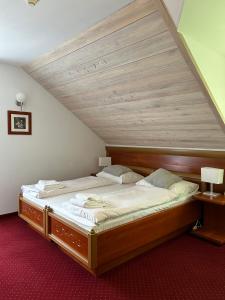 卡尔帕奇Hotel Promyk Wellness & Spa的一张位于带木制天花板的客房内的大床