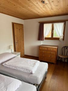 克洛斯特斯Ferienwohnung Crameri的一间卧室设有两张床和木制天花板
