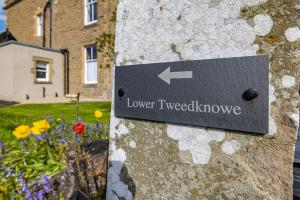 梅尔罗斯Lower Tweedknowe - ground floor villa Melrose的花卉石墙边的标志