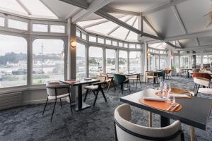 欧迪耶讷Logis hôtel restaurant Le Goyen的餐厅设有桌椅和窗户。