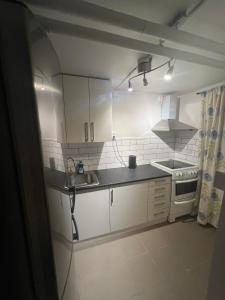吕勒奥Lägenheter i Luleå的厨房配有白色橱柜、水槽和炉灶。