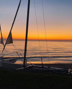 SengaJoma Adventure Lodge的日落时在海滩上乘坐帆船