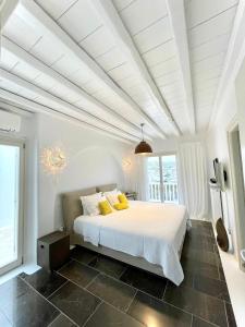 米克诺斯城Grace Villa Mykonos的卧室配有一张带黄色枕头的大型白色床。
