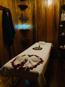 明多Guayabo Hostal Spa的一间房间,床上有白色的毯子和鲜花