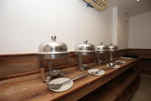 阿姆利则Hotel RV Regency的木柜台上的一排银盆和锅