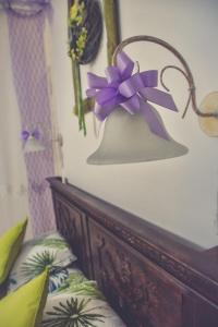 瑙吉伯尔热尼埃德奥桑温德加斯旅馆的床上一盏灯,上面有紫色的弓