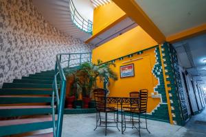 蓬蒂切里La Courtyard的一间带桌椅和楼梯的餐厅