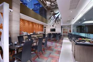 泗水Hotel Neo Gubeng by ASTON的一间带桌椅的餐厅和一间酒吧