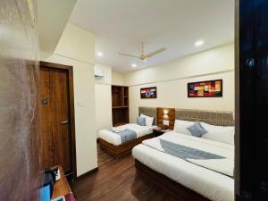 孟买Hotel Akasa Inn的酒店客房配有两张床和一张书桌