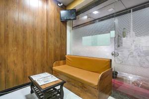 孟买Hotel Akasa Inn的客房设有长凳、桌子和电视。