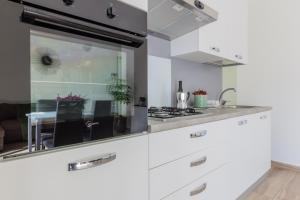 皮亚琴察Maggie House的厨房配有白色橱柜和水槽