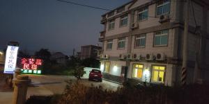 金宁乡馨紫晶民宿的前面有 ⁇ 虹灯标志的建筑