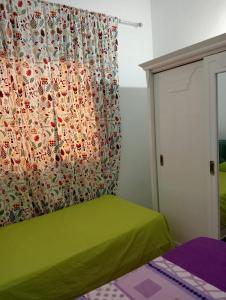 古莱比耶Maison a louer à kelibia的一间卧室配有绿色的床和窗帘