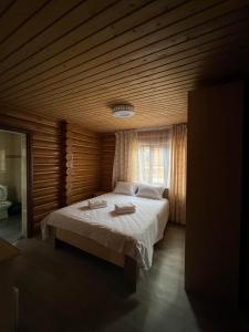 博斯特里Soho Hutor的一间卧室设有一张带木制天花板的大床