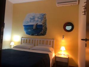 兰佩杜萨Villette ad uso turistico Lampedusa的卧室配有一张床,墙上挂有绘画作品