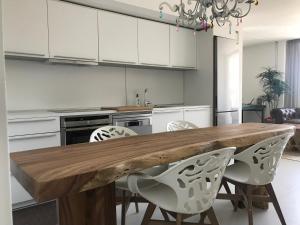 伊维萨镇LA MAISON BLANCHE IBIZA 5*的厨房配有木桌和白色橱柜。