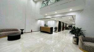 拉合尔Premium 1BR DHA Phase 5的大楼内一个带沙发和椅子的大型大堂