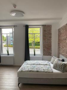 埃姆登Appartementhaus EMDEN的一间卧室设有一张床和两个窗户。