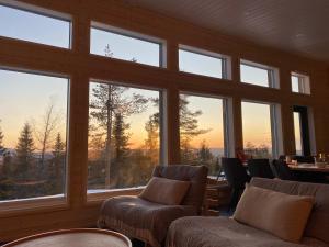 索特Näköalahuvila Pikku-Syötteen Helmi的客房设有带椅子和桌子的大窗户。