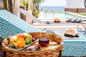 吉奥塔略Heliophos Villa Aelia的桌上的水果篮和一杯葡萄酒