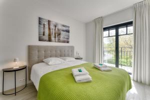 克诺克－海斯特Zonnig Luxueuze Appartementen La Coronne的白色卧室配有一张大床和毛巾