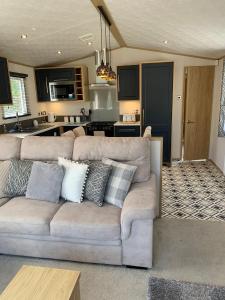 UlromeThe Luxe Lodge, Skipsea Sands Bridlington的带沙发的客厅和厨房