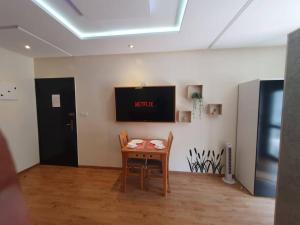 拉巴特DOUBLE Studio的一间设有桌子和墙上电视的房间