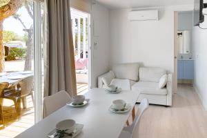 托里代巴拉Camping Relax Sol的白色的客厅配有白色的桌子和椅子
