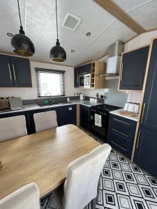 UlromeThe Luxe Lodge, Skipsea Sands Bridlington的厨房配有木桌和椅子