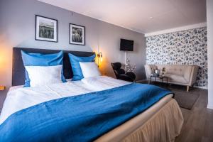 霍耶Marsk Hotellet的卧室配有蓝色和白色的床和椅子