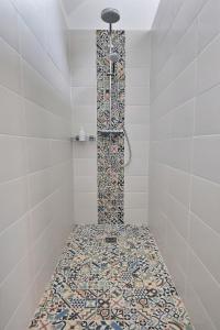 博韦Chambres Beauvais的浴室设有马赛克地板和淋浴。