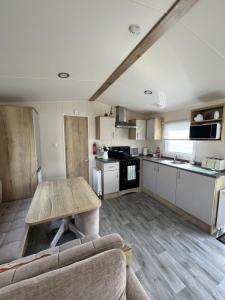 UlromeCosy Caravan的厨房以及带木桌的起居室。