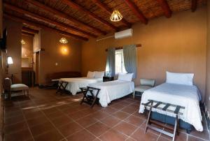 蒂诺加斯塔Hotel de campo luna的一间设有两张床和一张桌子及椅子的房间