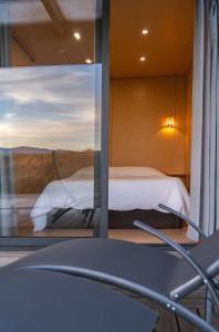 O Refugio Nas Vinhas的透过玻璃窗可欣赏到卧室的景色