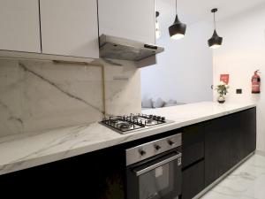 迪拜VESTA - Dubai Residence的厨房配有白色大理石台面和炉灶。