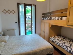 蒙泰克雷托Bilocale Gran Chalet Montecreto的卧室配有一张双层床,位于门边