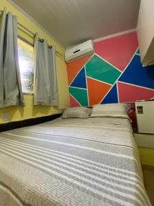 萨尔瓦多Hostel Sol da Barra的一张位于多彩墙上的床铺