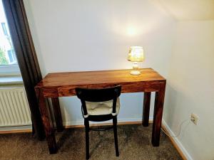比勒费尔德Apartment Jackie 2的一张桌子,上面有椅子和一盏灯