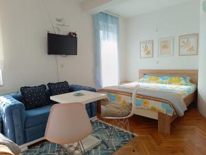 弗拉涅Vila Sentić的一间卧室配有一张床和一张蓝色的沙发