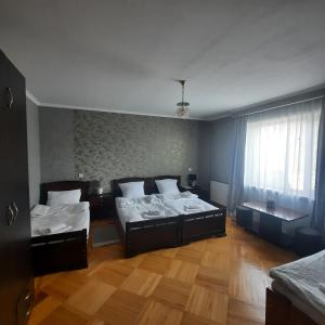 卡兹贝吉GIO-NIKA的一间卧室设有两张床、一个窗户和木地板。