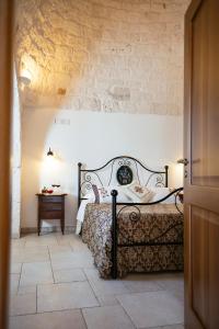 阿尔贝罗贝洛Trulli Magravì - Apparthotel的一间卧室设有一张床和石墙