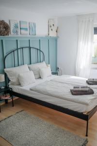 BreitscheidBUCHLINDENWEG - Zimmer & Ferienwohnung的卧室内的一张床铺,卧室内有蓝色的墙壁