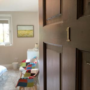 霍特惠斯尔Belford House Self Check-in Rooms的一个带椅子和床的门的房间