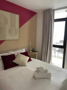 阿罗纳Stunning lovely flat with Pool and strong Wi-Fi的一间卧室配有一张大床和两条毛巾