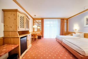 兰格劳塞霍夫斯特兰德酒店的酒店客房设有一张大床和一张书桌。