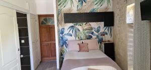 佩兹纳斯Au logis de Pézenas的一间卧室配有一张带热带壁纸的床