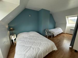 LʼIsle-Saint-CastMaison Quartier de la Fresnaye 8 personnes的卧室配有白色的床和蓝色的墙壁