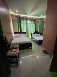 坎帕拉Suzie hotel的一间卧室设有两张床、一张沙发和一个窗口