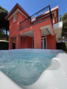 罗索利纳马雷Principesse的房子前面的房屋设有热水浴池